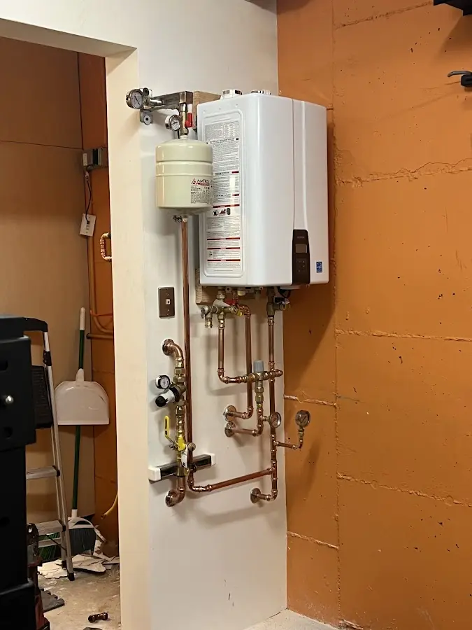 Plumbing technician inspecting water heater connections in Prescott